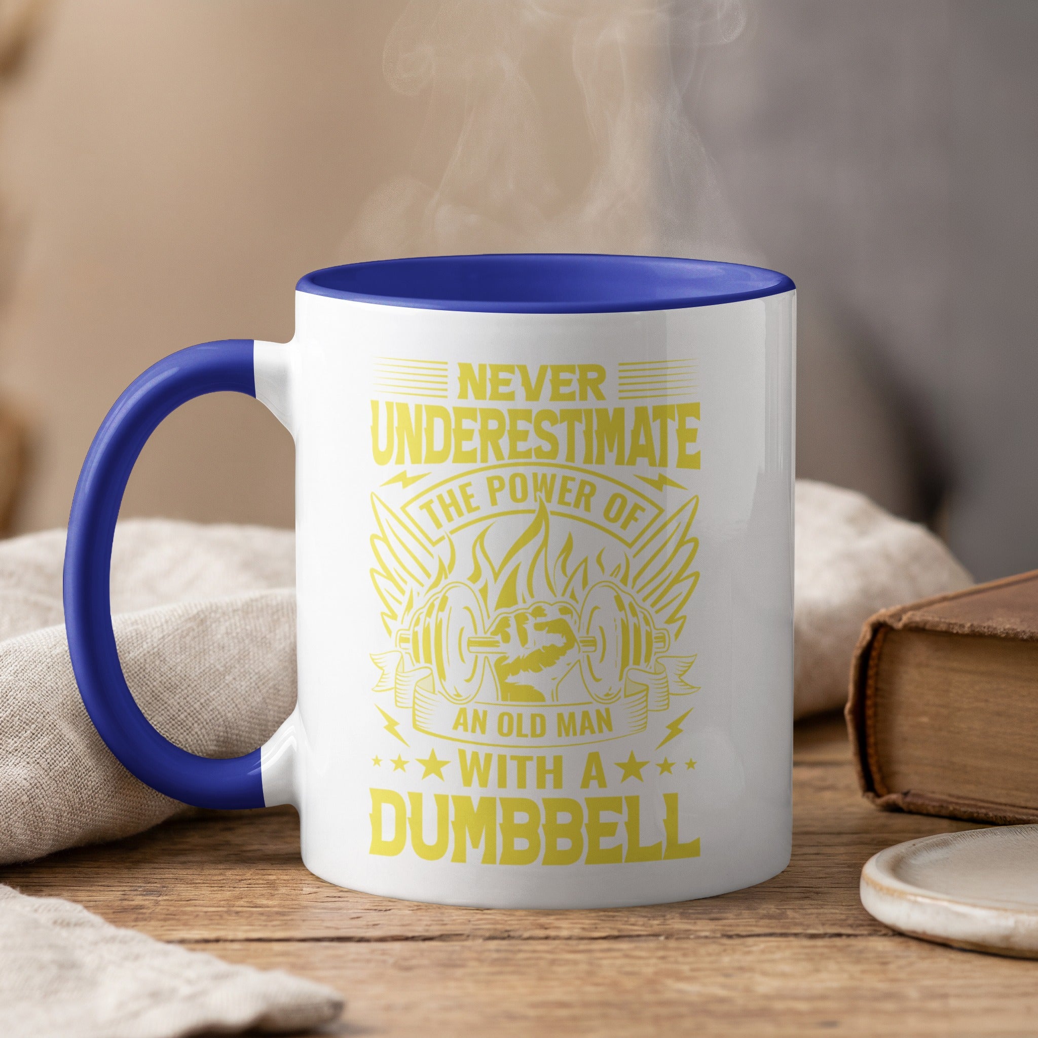 Mug with "Never Underestimate the Power of an Old Man With a Dumbbell" text and barbell graphic.