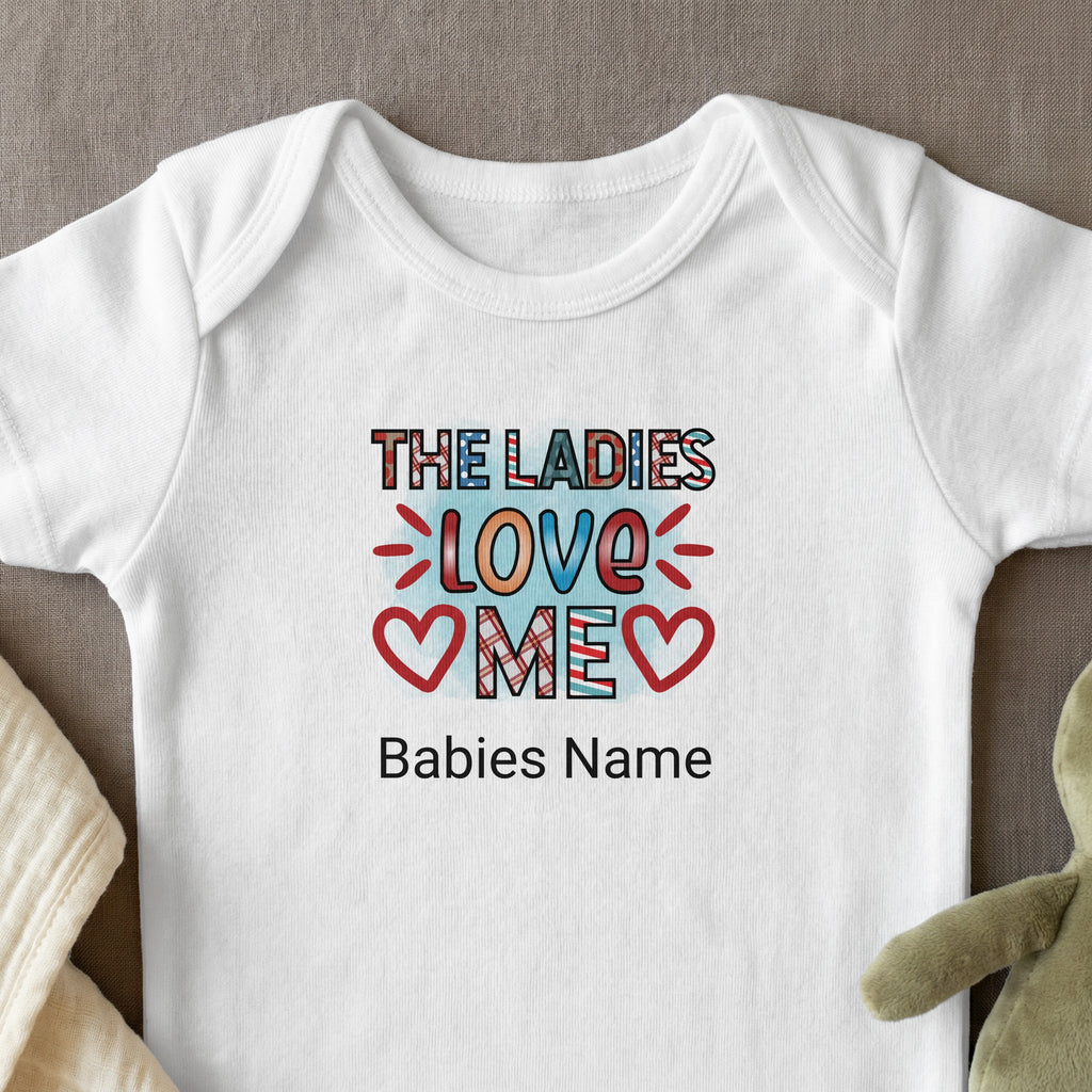 White baby onesie with "The Ladies Love Me" design and space for name.