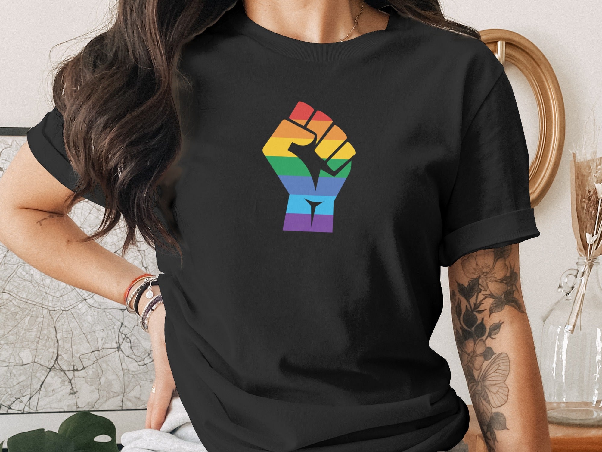 Black t-shirt with rainbow fist graphic and purple accents at the bottom.