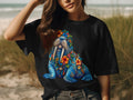 Black t-shirt with a colorful walrus adorned with flowers and shells.