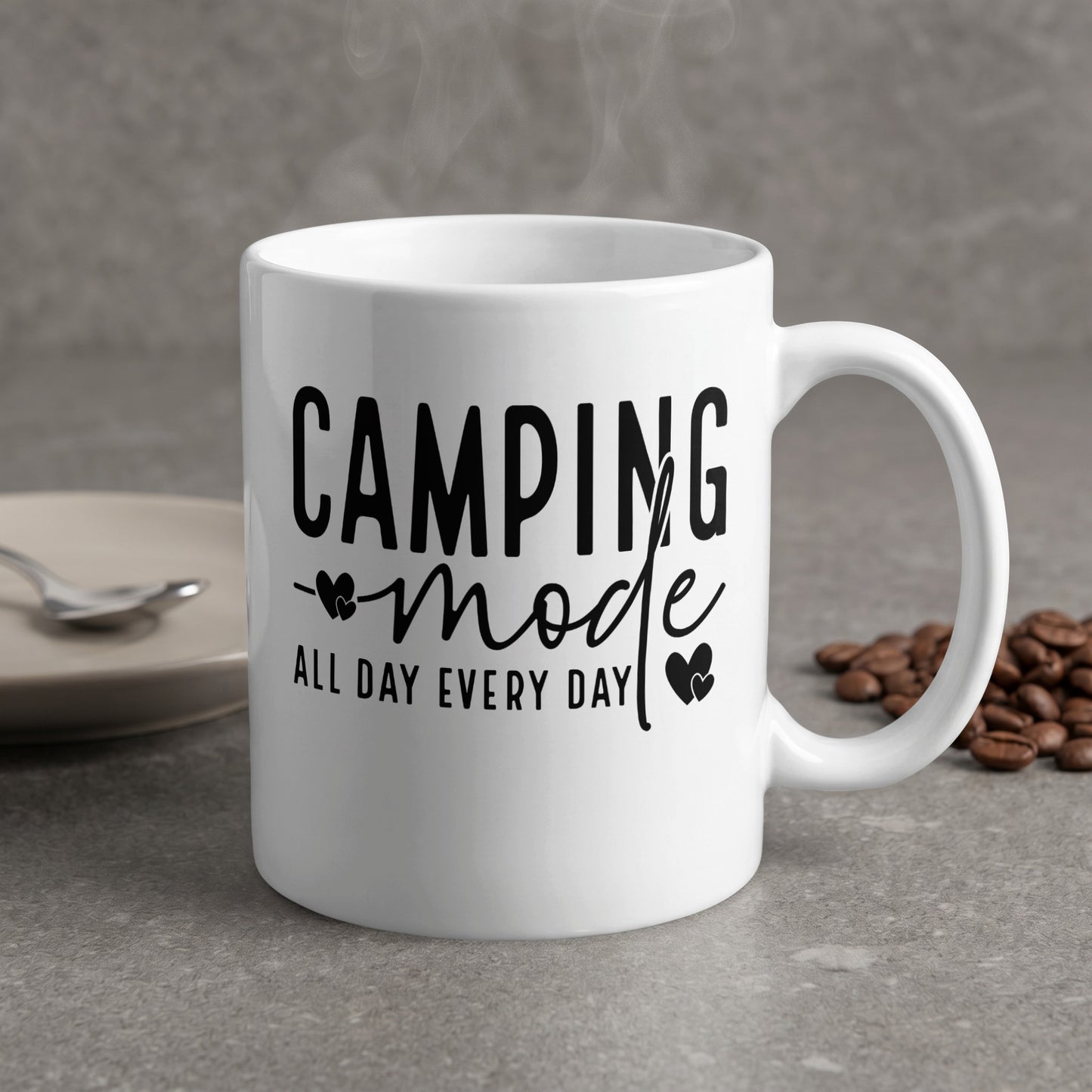 White mug with "CAMPING mode ALL DAY EVERY DAY" text and steam rising.