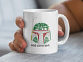 White mug with Boba Fett helmet design made of text.