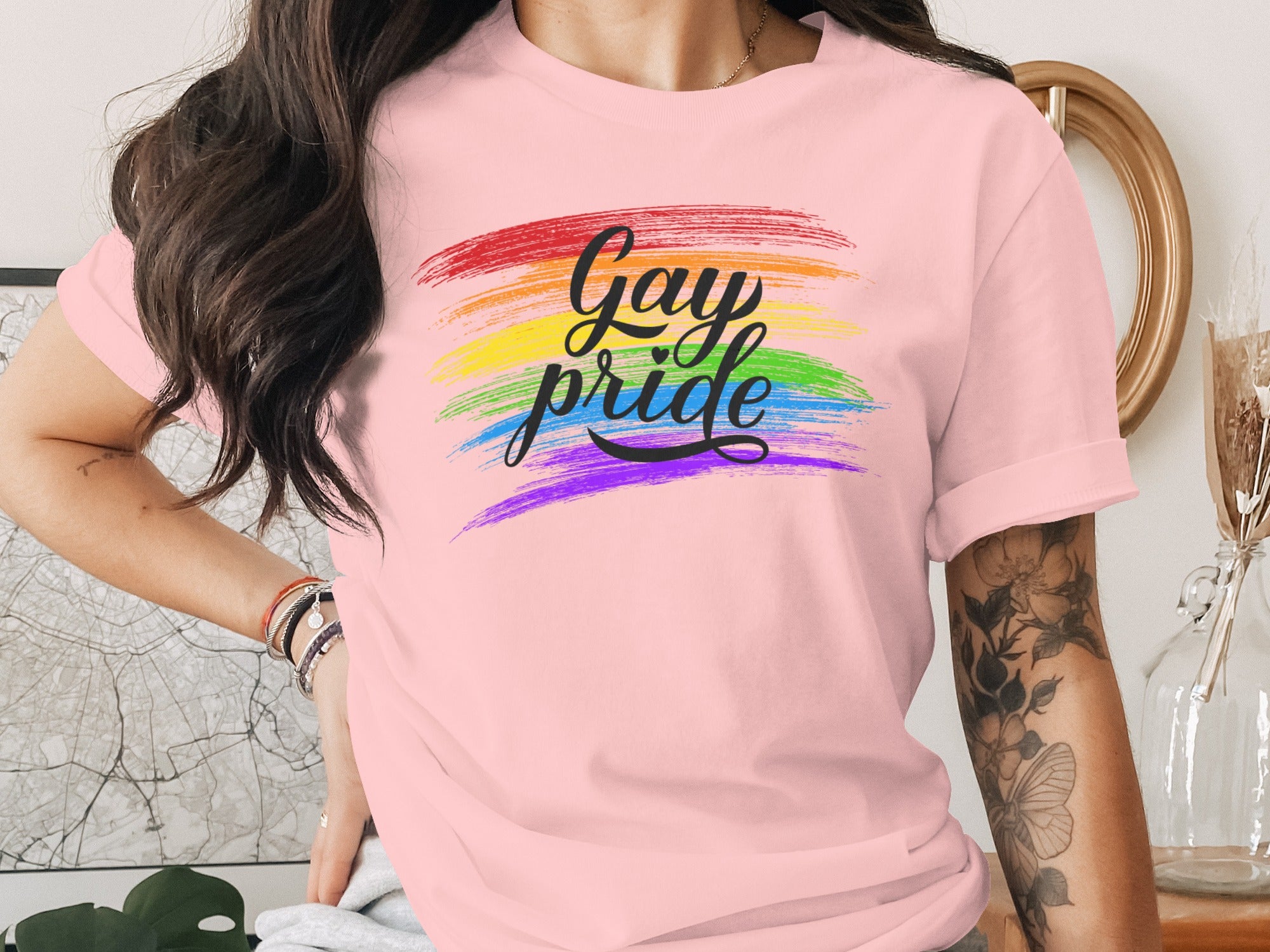 Pink t-shirt with "Gay pride" in black script over rainbow brush strokes.