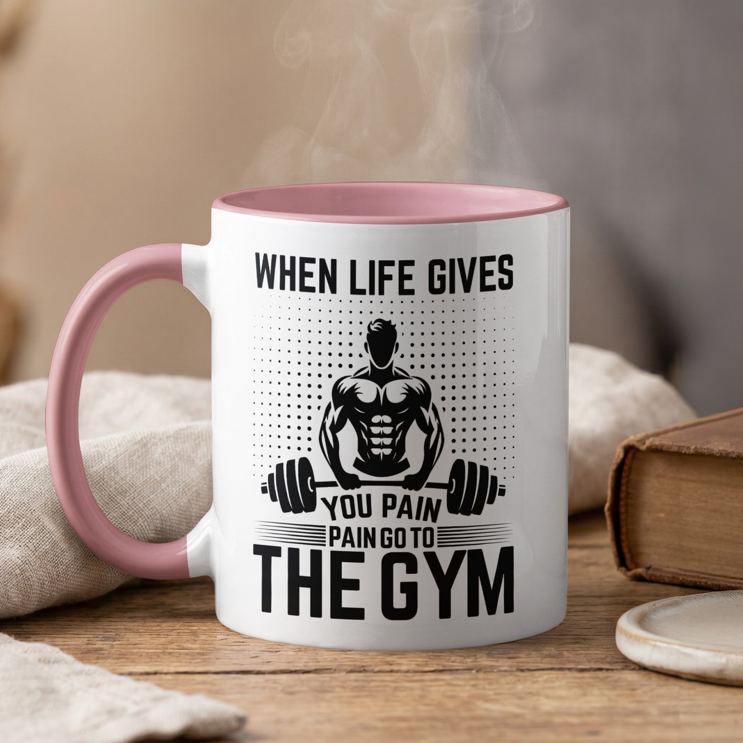 White mug with pink handle, saying "When life gives you pain go to the gym".
