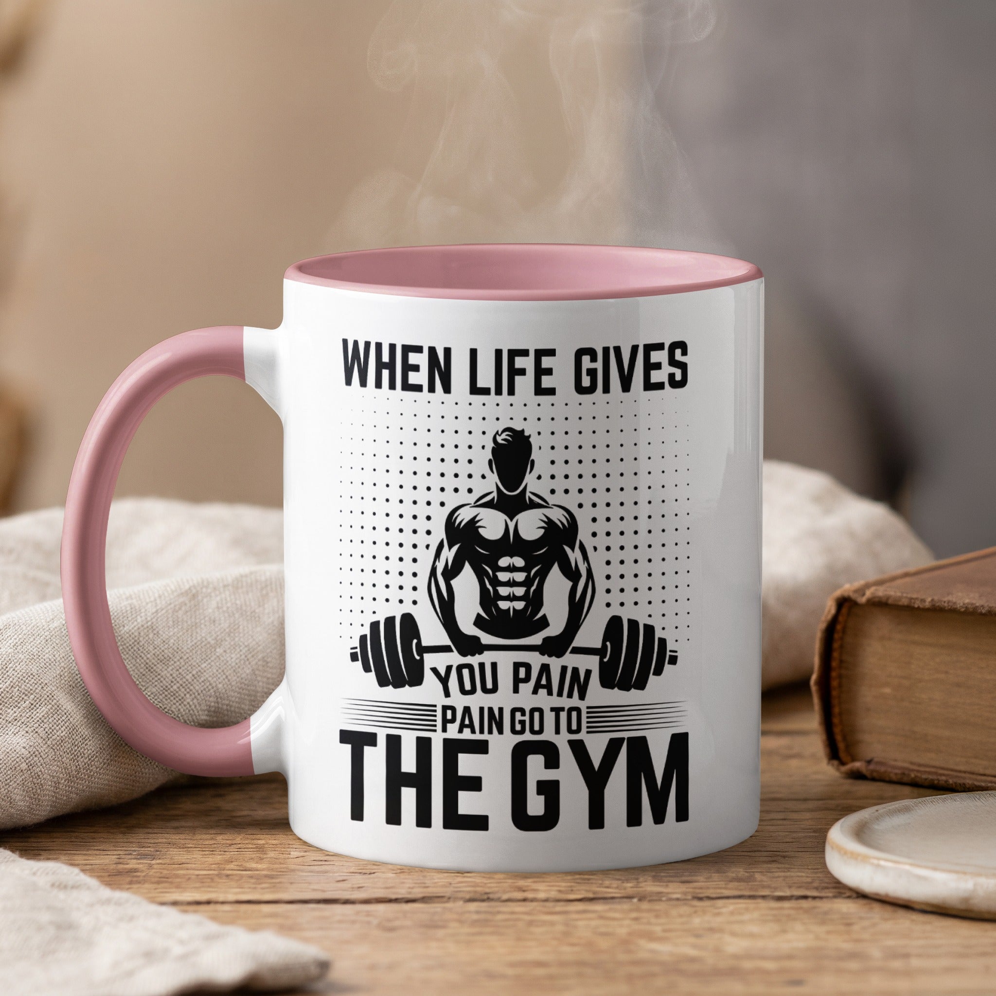 White mug with pink handle, saying "When life gives you pain go to the gym".