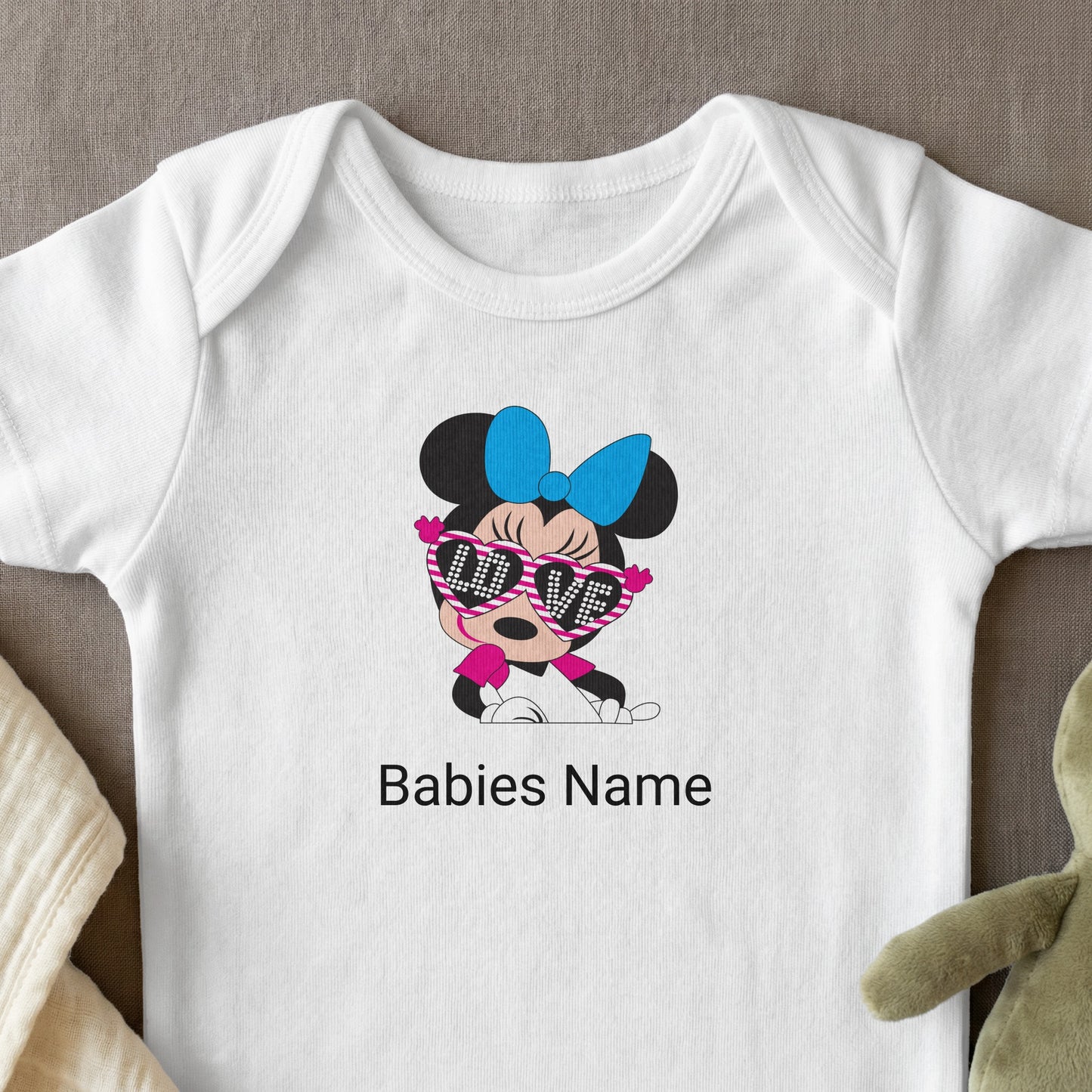 White baby onesie with Minnie Mouse graphic and "Babies Name" text.