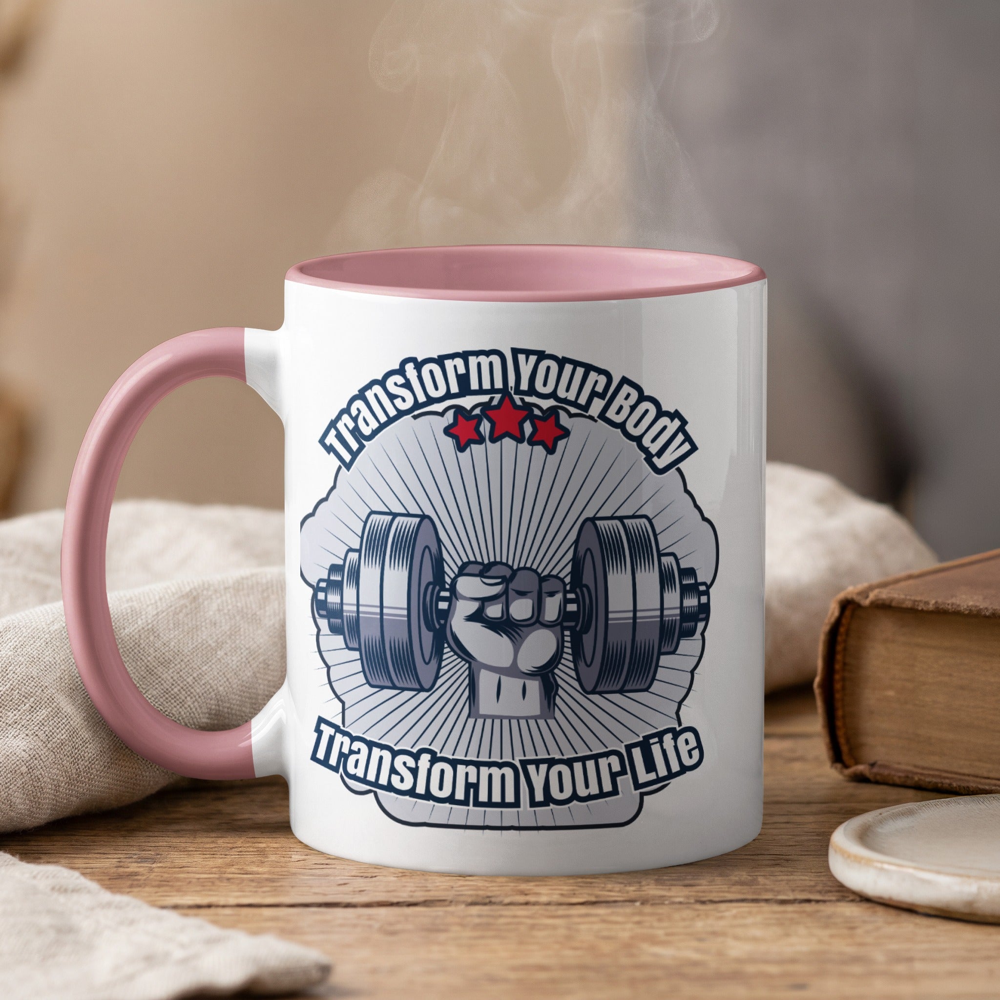 White mug with pink handle, featuring a barbell and "Transform Your Body Transform Your Life".