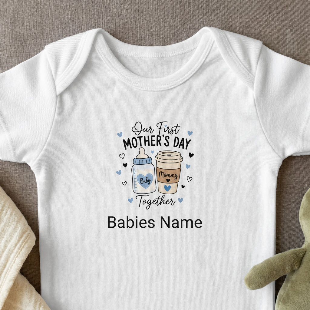 White baby onesie with "Our First Mother's Day Together" text and baby icons.