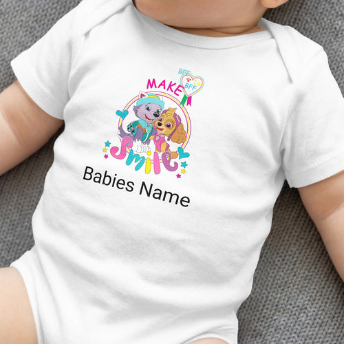 White baby onesie with "MAKE Babies Name SMILE" and cartoon dogs.