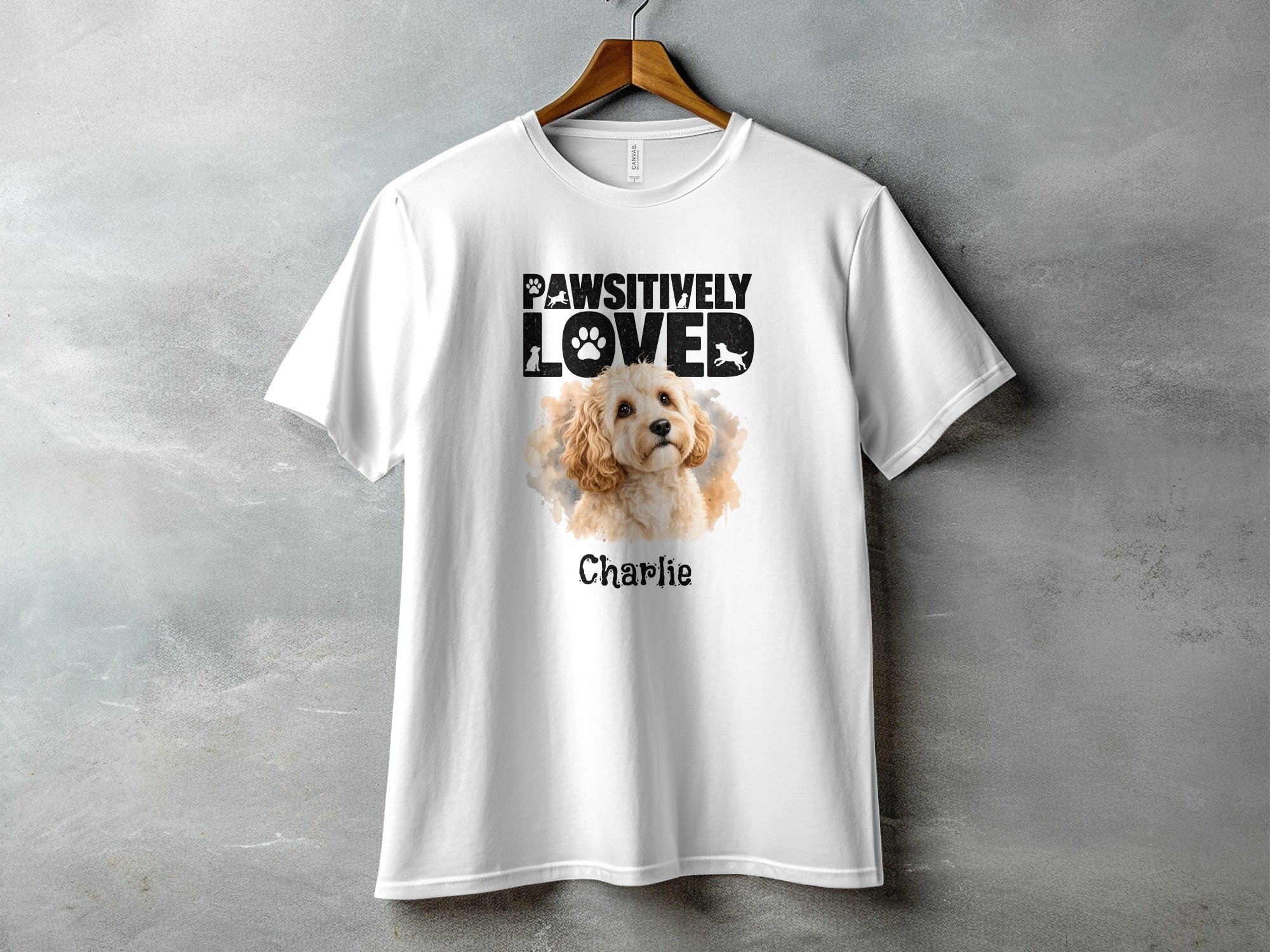 White t-shirt with "Pawsitively Loved" text and a dog illustration named Charlie.
