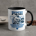 Mug with "PUSH HARDER THAN YESTERDAY" text and muscular man lifting weights.
