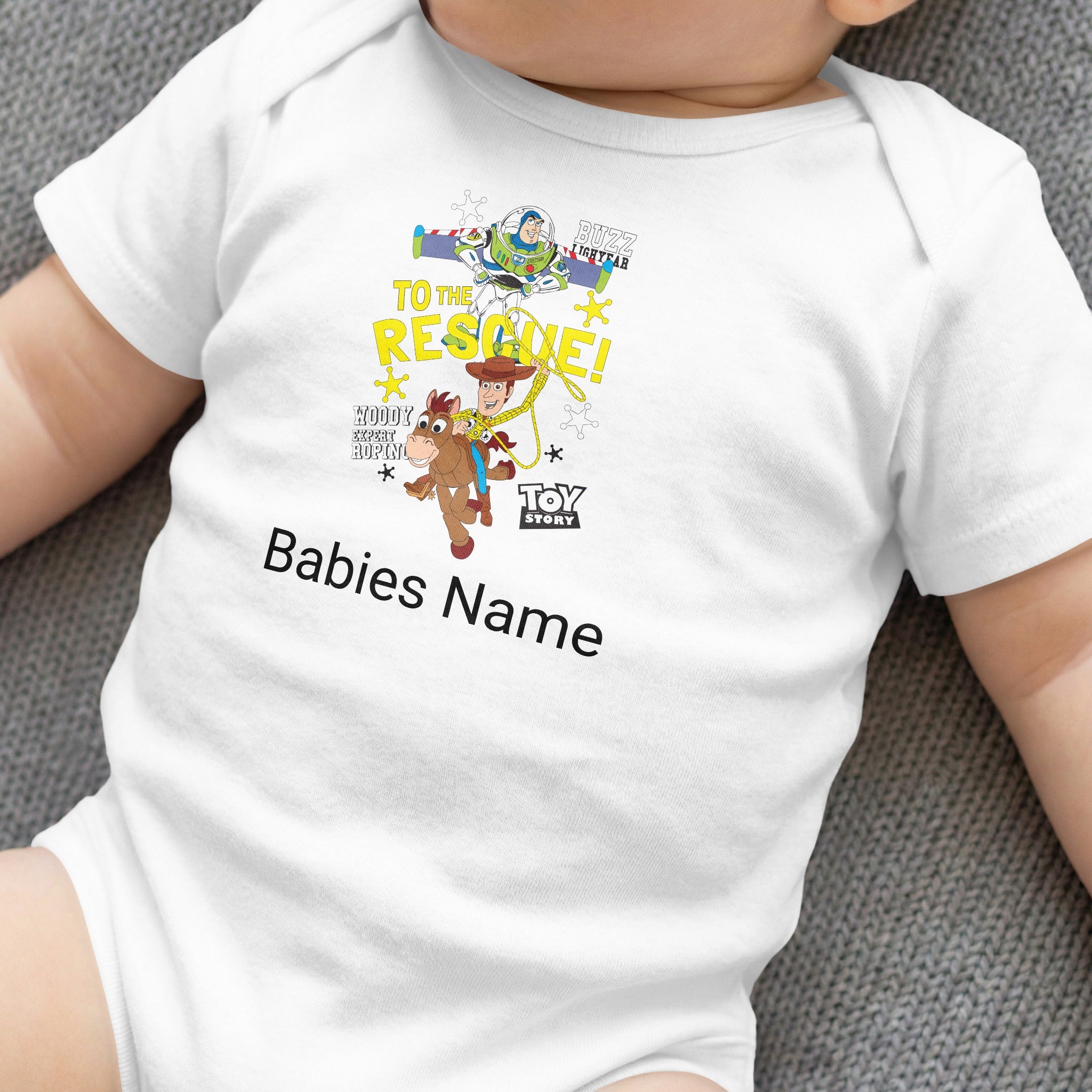 Toy Story graphic on a white baby onesie with "Babies Name" text.