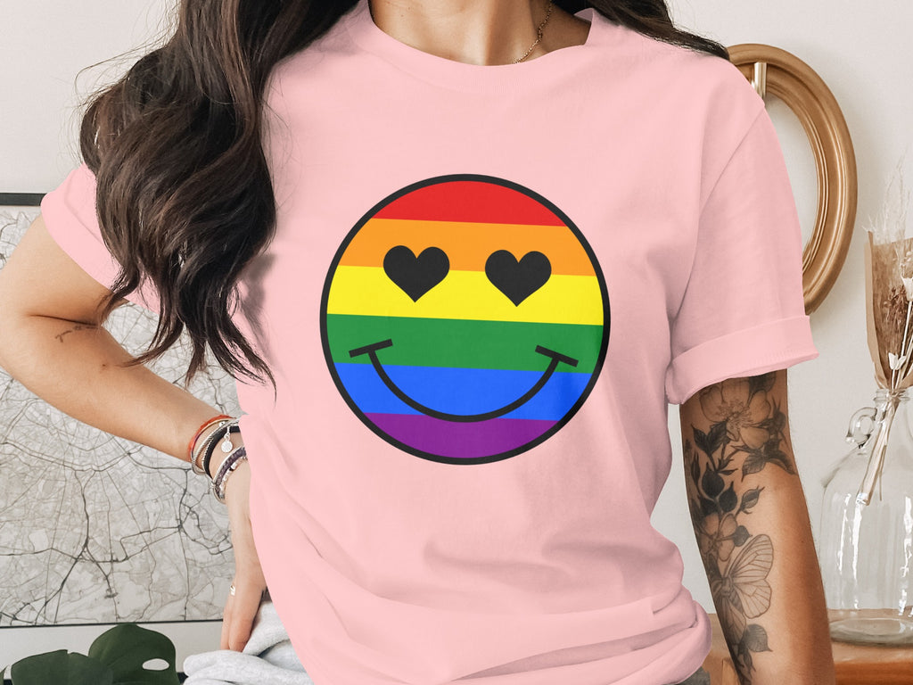 Pink t-shirt featuring a rainbow smiley face with heart-shaped eyes.