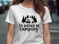 White t-shirt with black graphic of a camper, trees, and stars, and text "I'D RATHER BE camping".