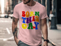 Pink t-shirt with rainbow text that says "BORN THIS GAY" with a red heart.