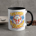 White mug with "UNLEASH THE BEAST" text and muscular figure graphic.