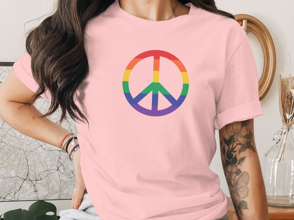 Pink t-shirt with rainbow peace symbol on chest.