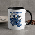 White mug with black rim featuring a muscular man and barbell, text "NO PAIN NO GAIN".