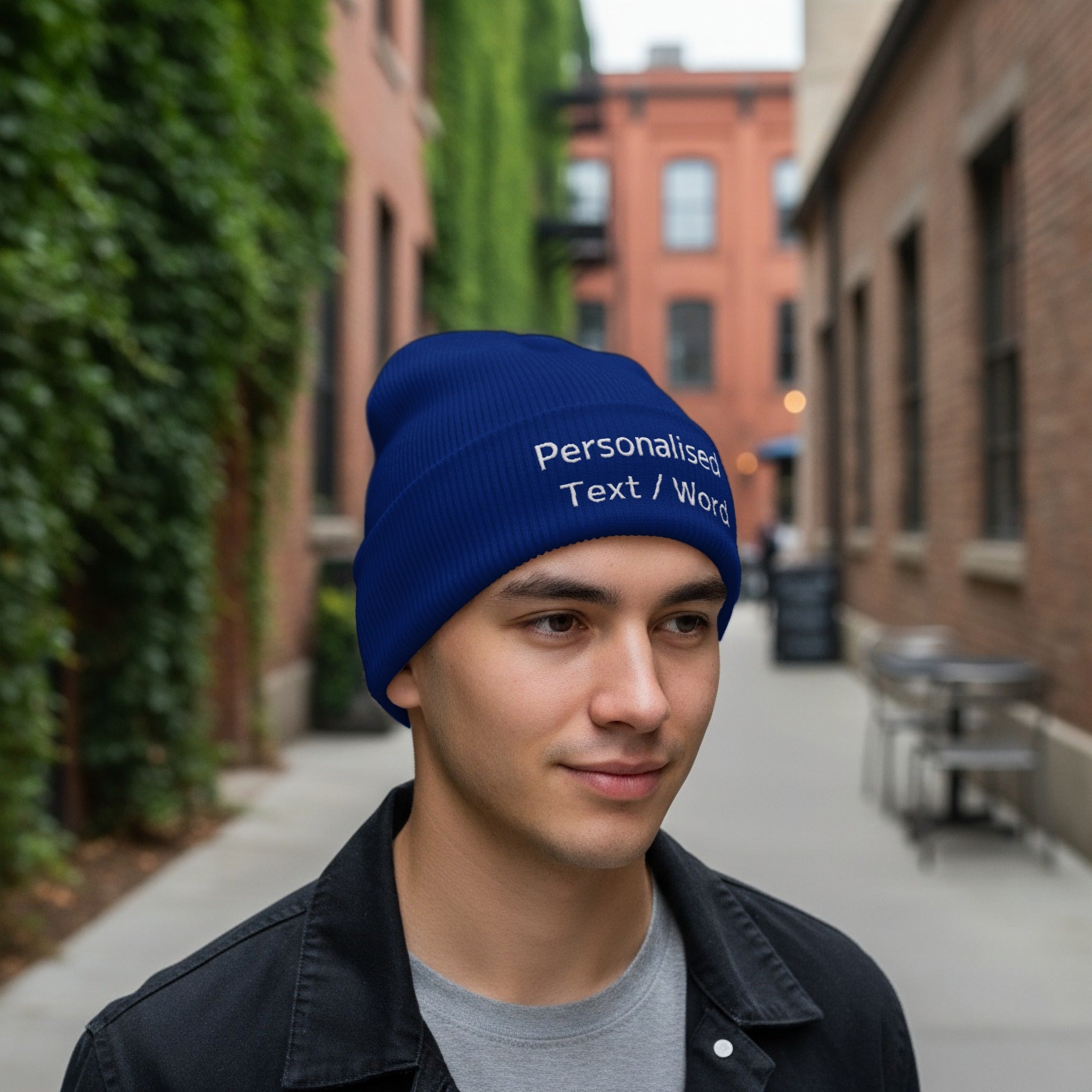 Man wearing a blue knit beanie with "Personalised Text / Word" embroidered in white.