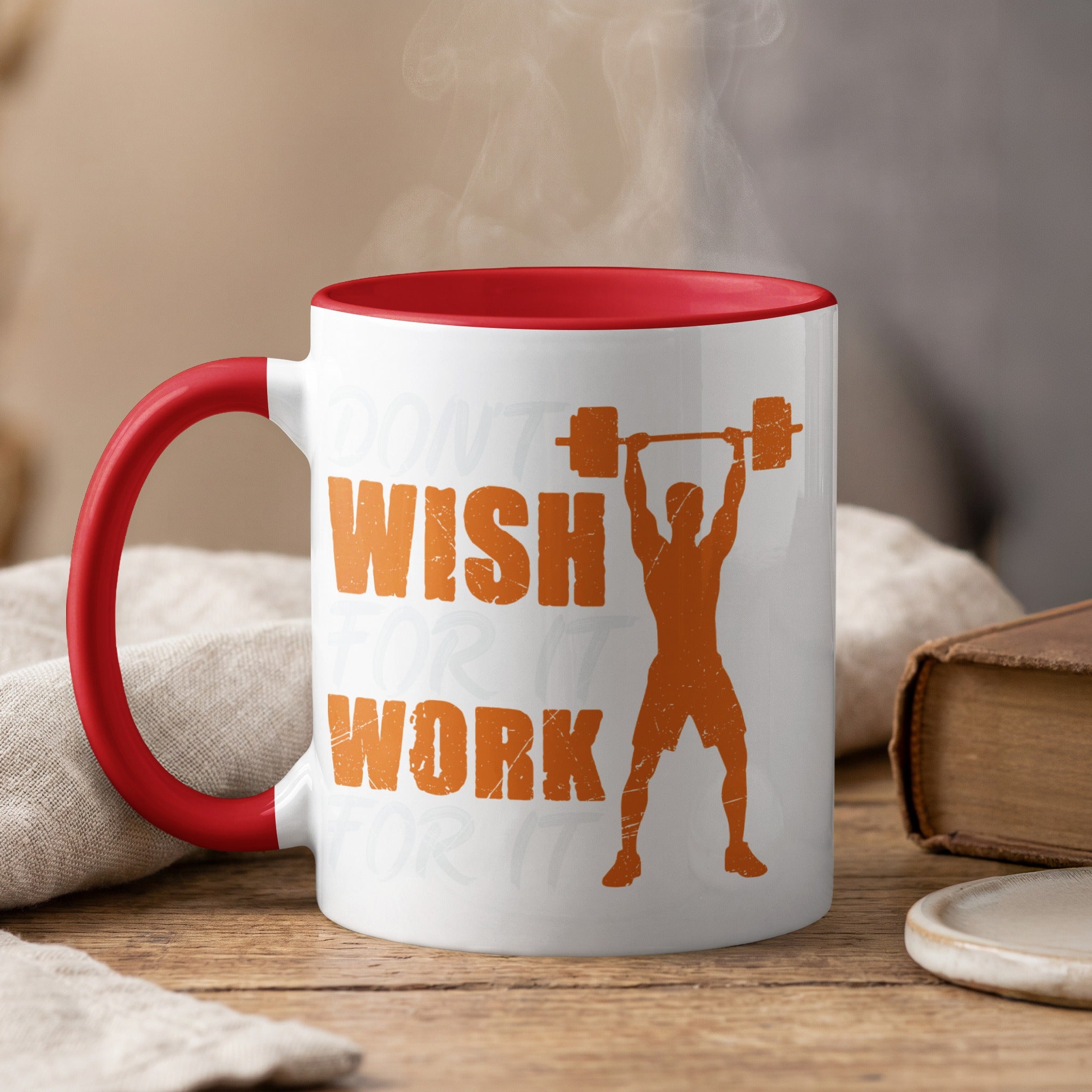 White mug with red rim, orange text and silhouette of person lifting weights.