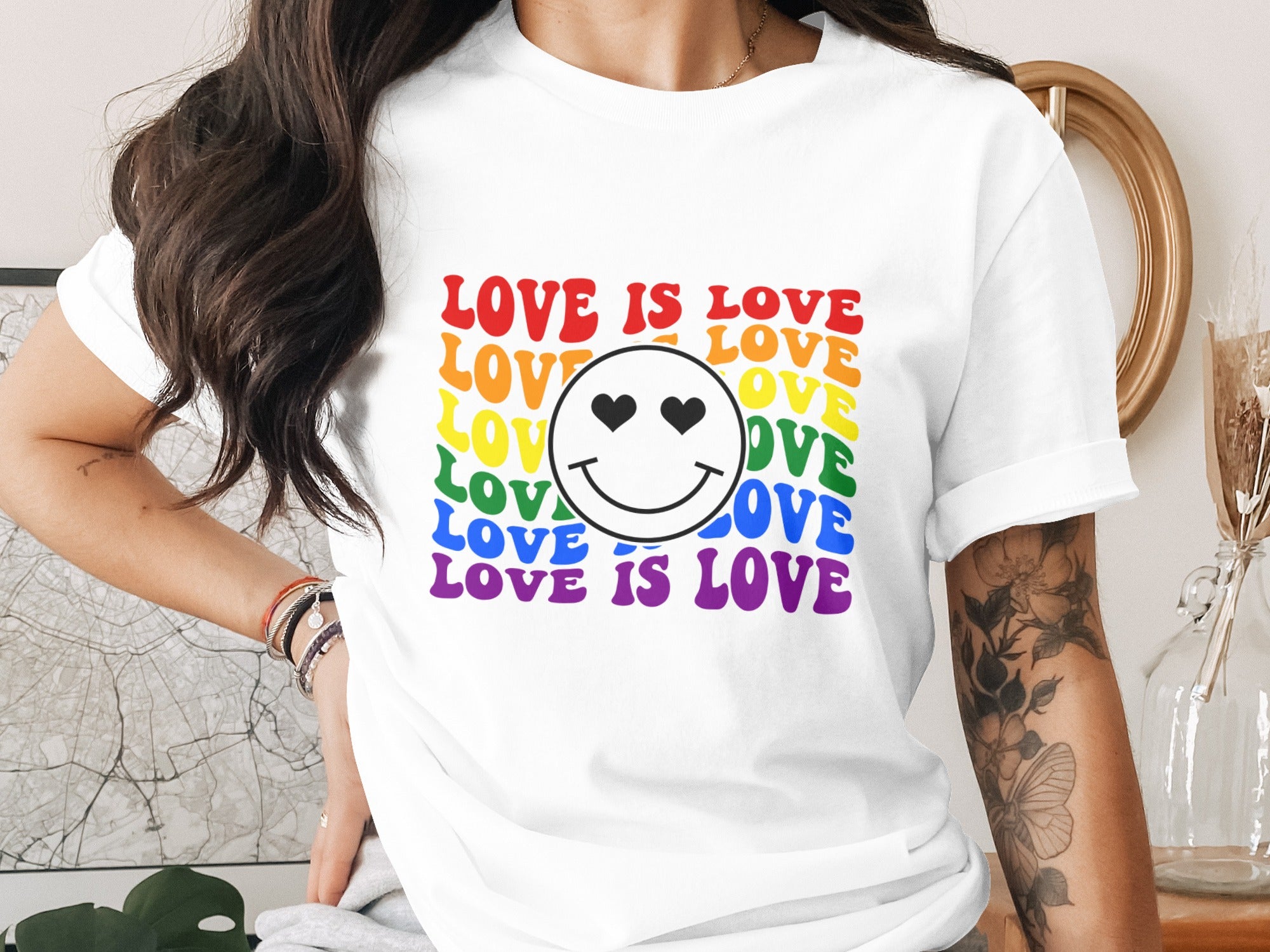 White t-shirt with rainbow "LOVE IS LOVE" text and smiley face with heart eyes.
