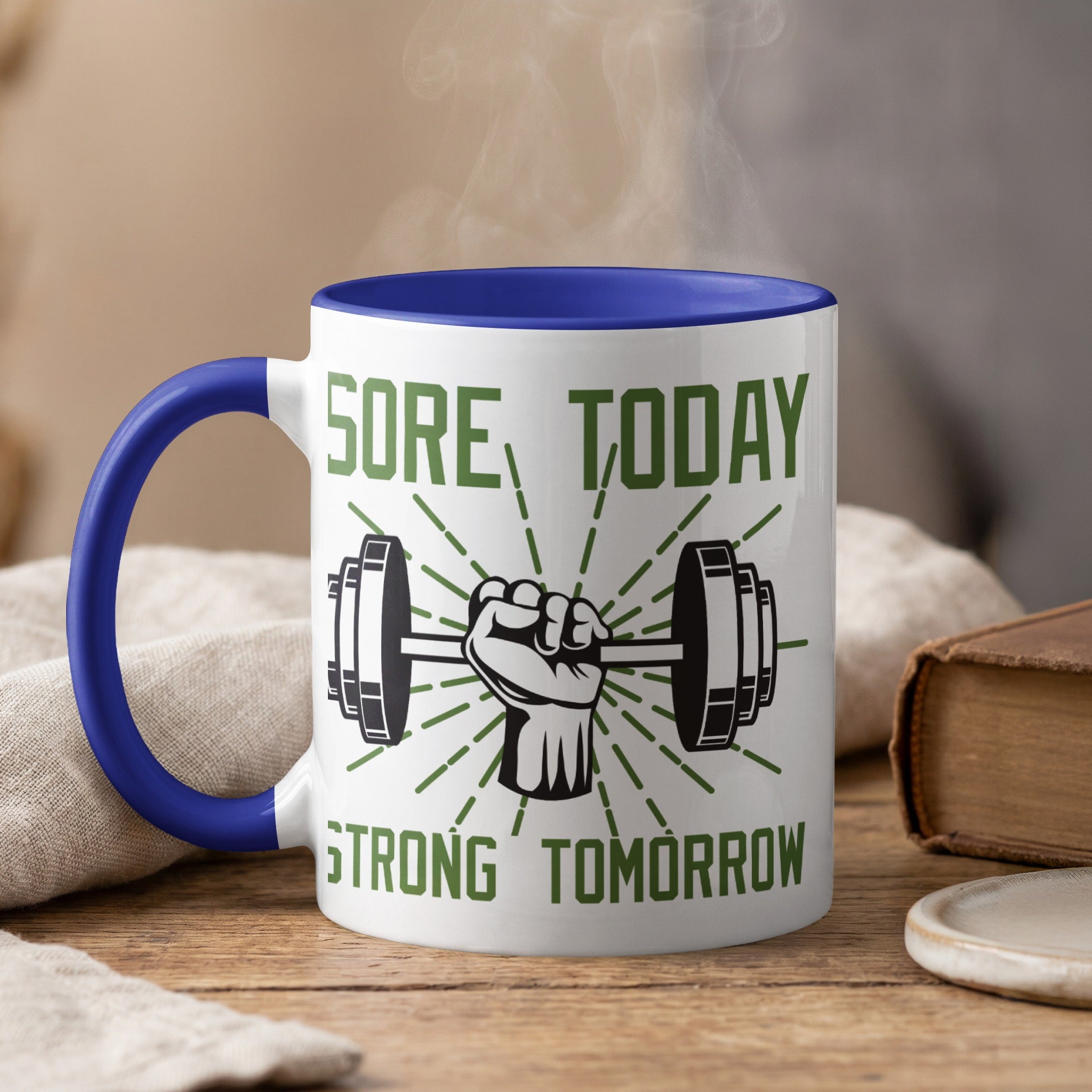 Mug with "SORE TODAY STRONG TOMORROW" text and a flexing arm holding a dumbbell.