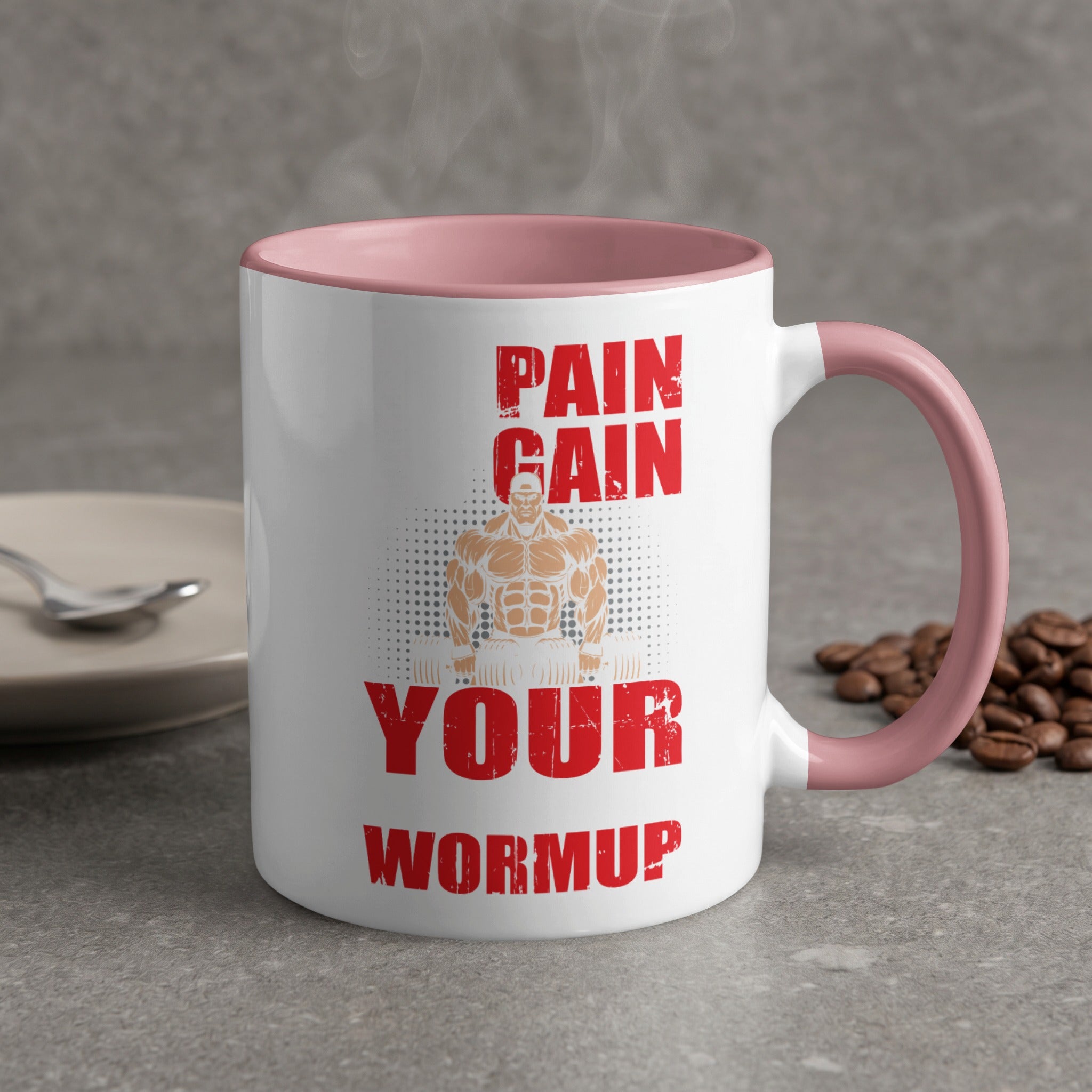 White mug with pink rim displaying "PAIN GAIN YOUR WORMUP" and a muscular silhouette.