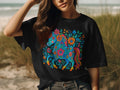 Black t-shirt with a colorful unicorn surrounded by flowers and leaves.