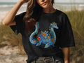 Black t-shirt with a blue sea serpent design made of flowers and paisley.