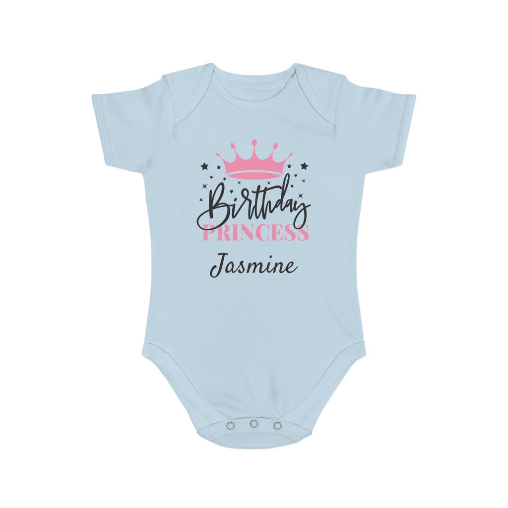 Light blue baby onesie with "Birthday Princess Jasmine" text and pink crown.