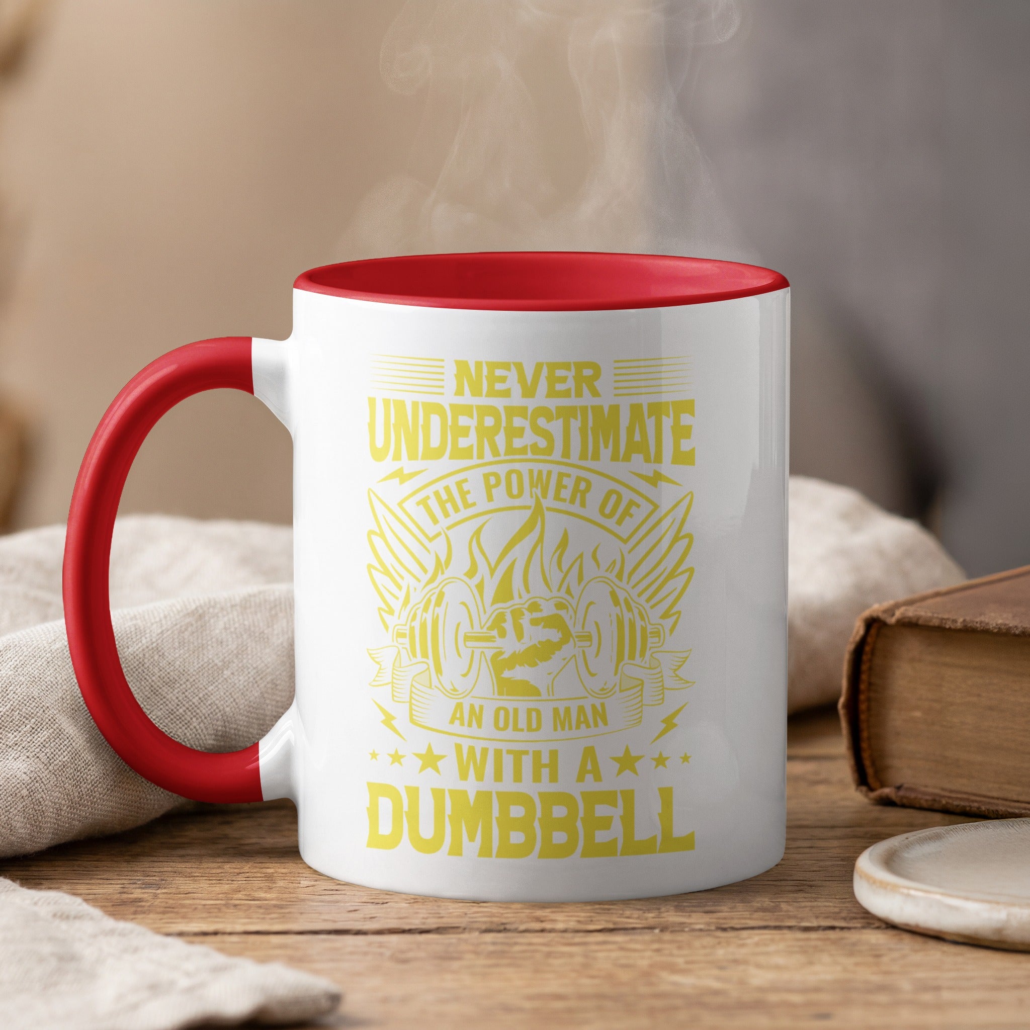 White mug with red interior and handle featuring "Never Underestimate The Power of An Old Man With A Dumbbell" text.