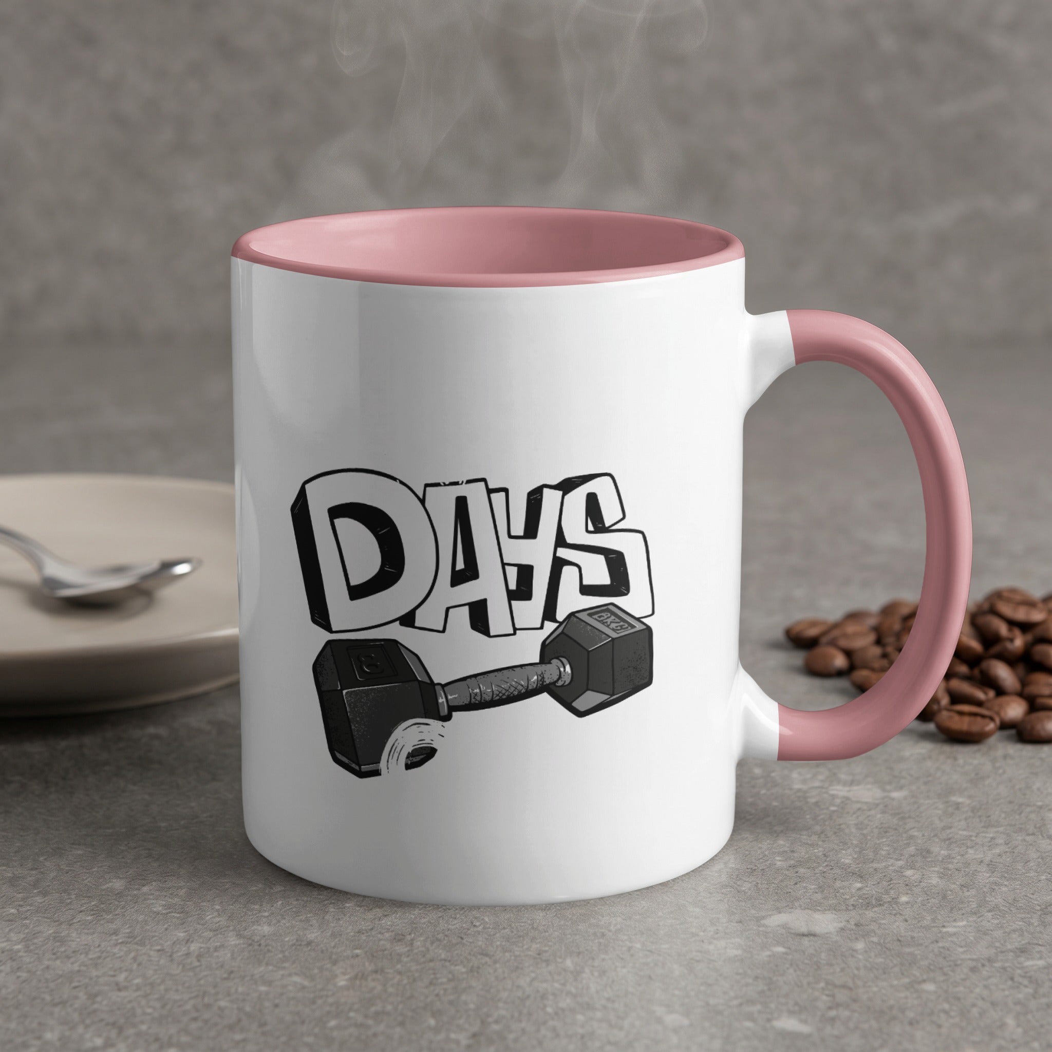 White mug with pink handle and "DAYS" text with dumbbell graphic.