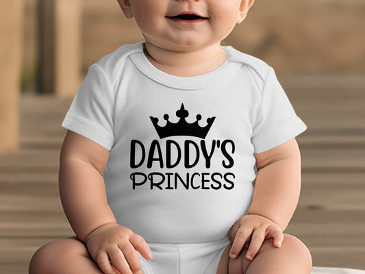 White baby onesie with black "DADDY'S PRINCESS" text and crown graphic.