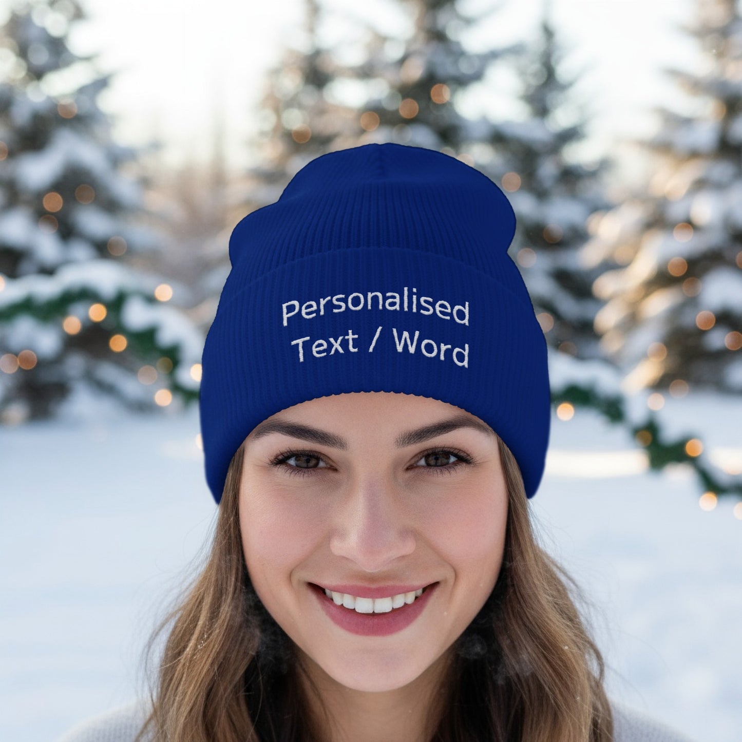 Blue beanie with embroidered text "Personalised Text / Word" worn in snow.