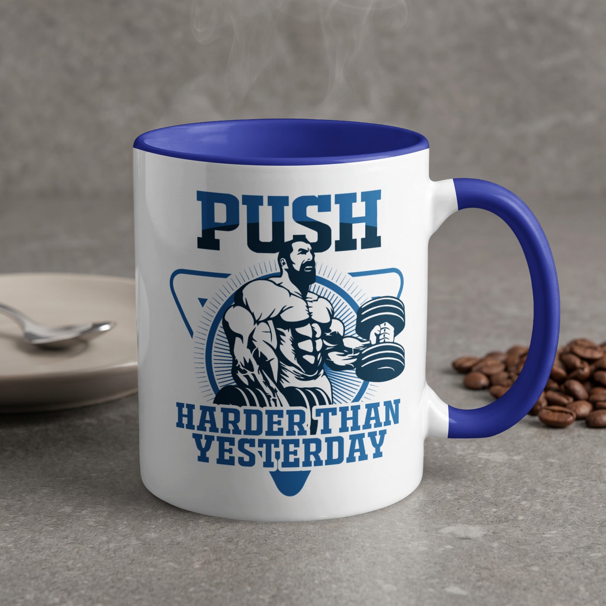 White mug with blue rim, featuring muscular man lifting weights and text "PUSH HARDER THAN YESTERDAY".