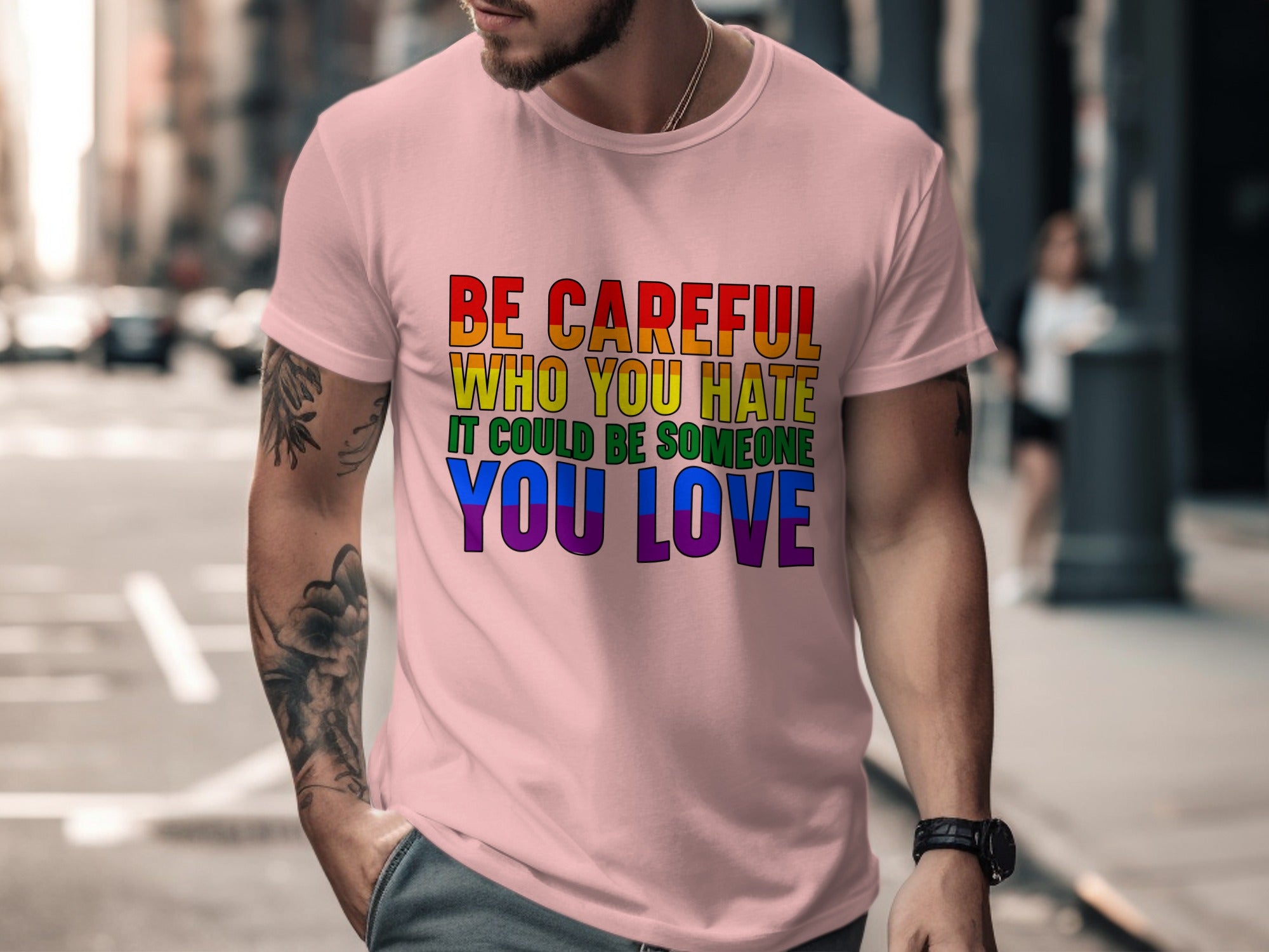 Pink t-shirt featuring rainbow text: "BE CAREFUL WHO YOU HATE IT COULD BE SOMEONE YOU LOVE".