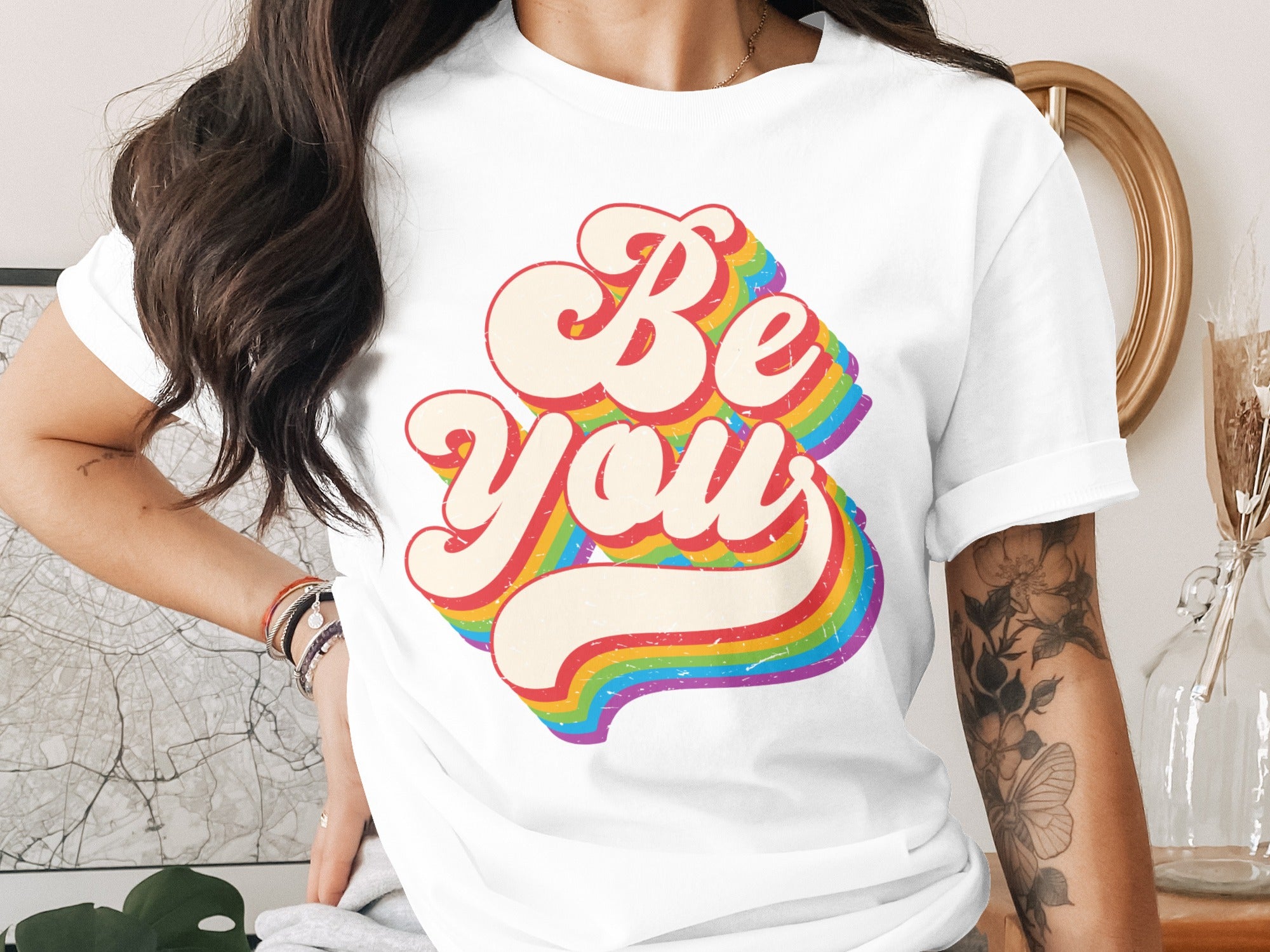 White t-shirt with "Be You" in retro rainbow lettering.