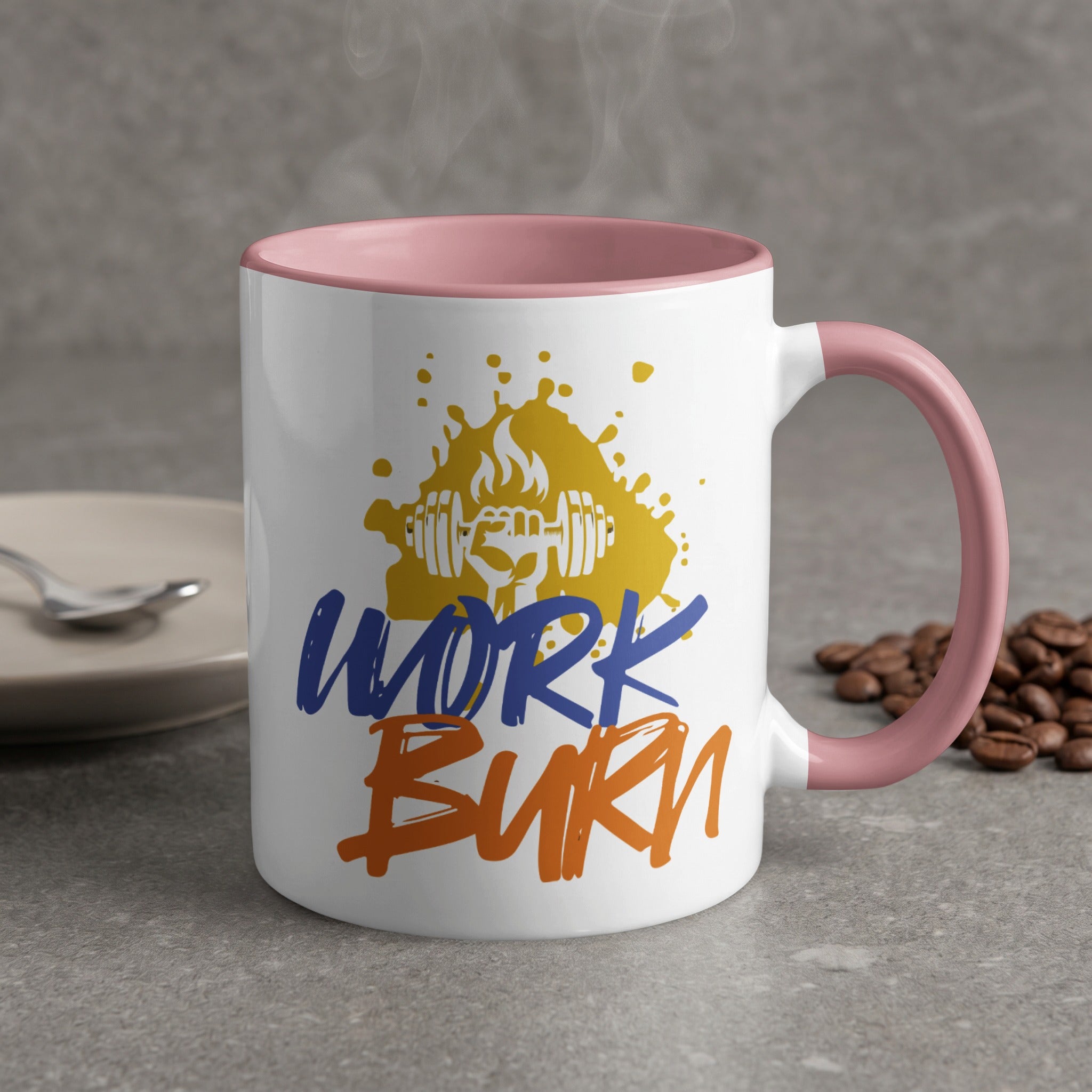 Mug with "WORK BURN" text and dumbbell graphic, pink handle, steam rising.