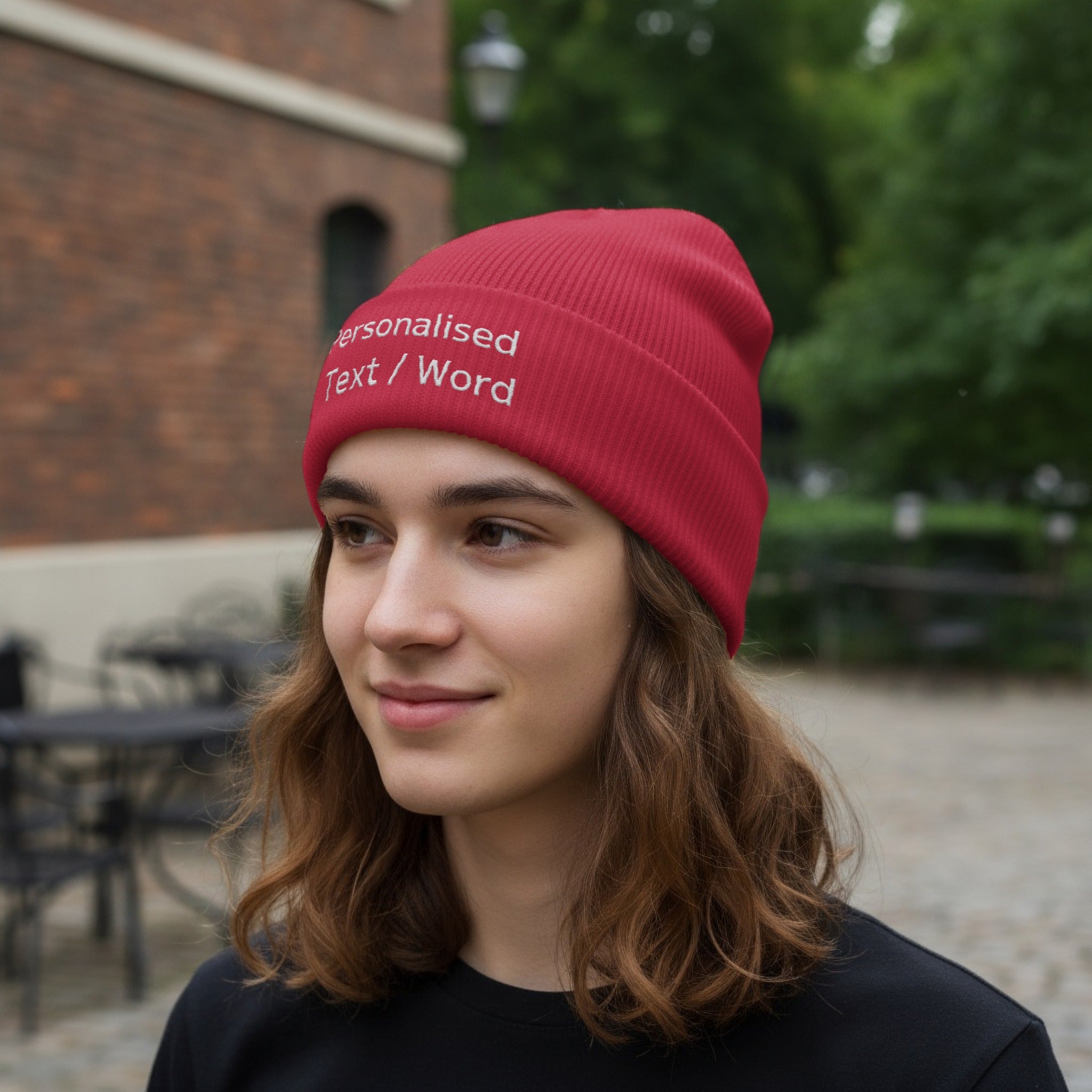 Red beanie with embroidered "Personalised Text / Word" worn by a person.