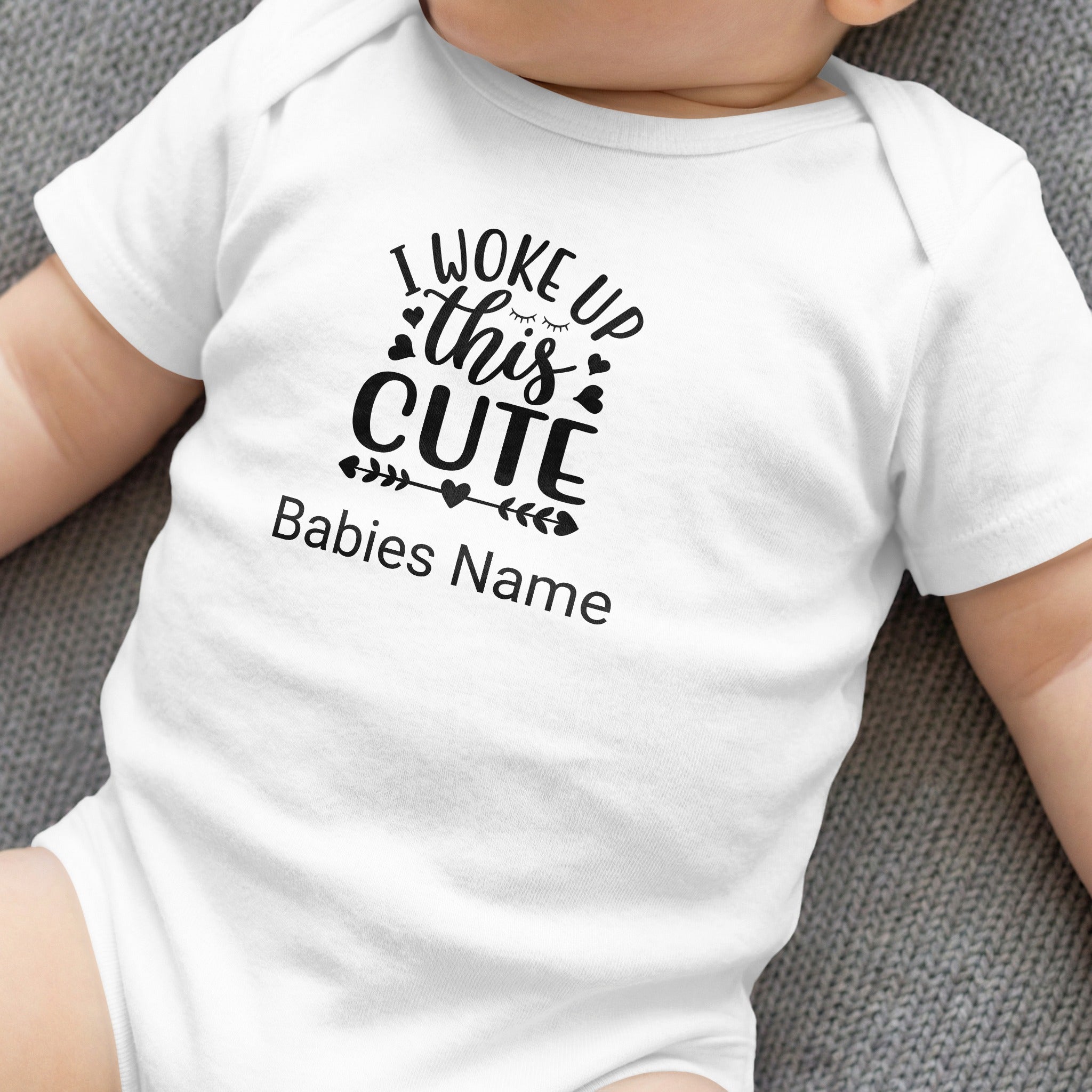 White baby onesie with "I Woke Up This Cute" text and baby's name.