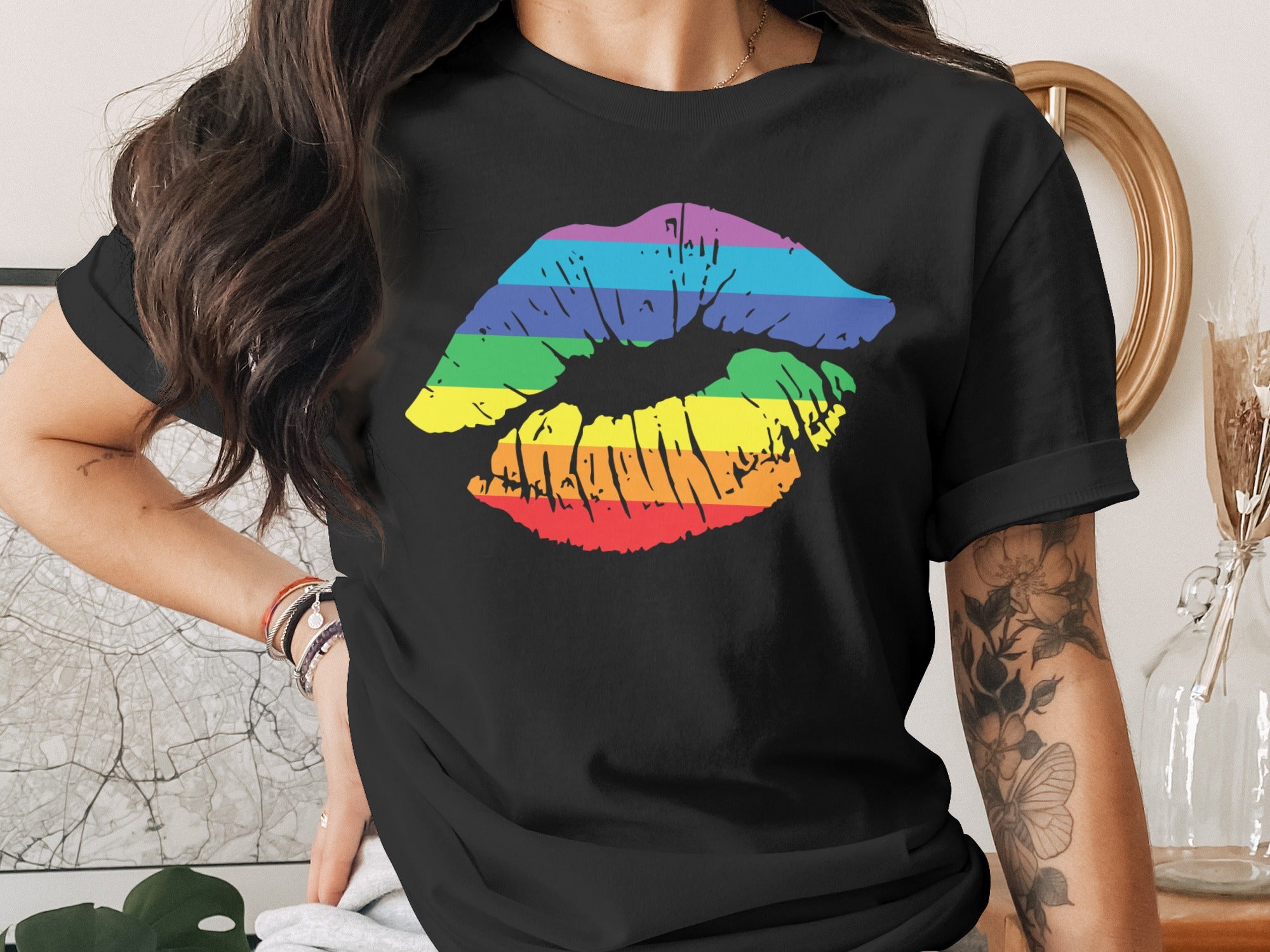 Black t-shirt with rainbow lips graphic and floral arm tattoo.