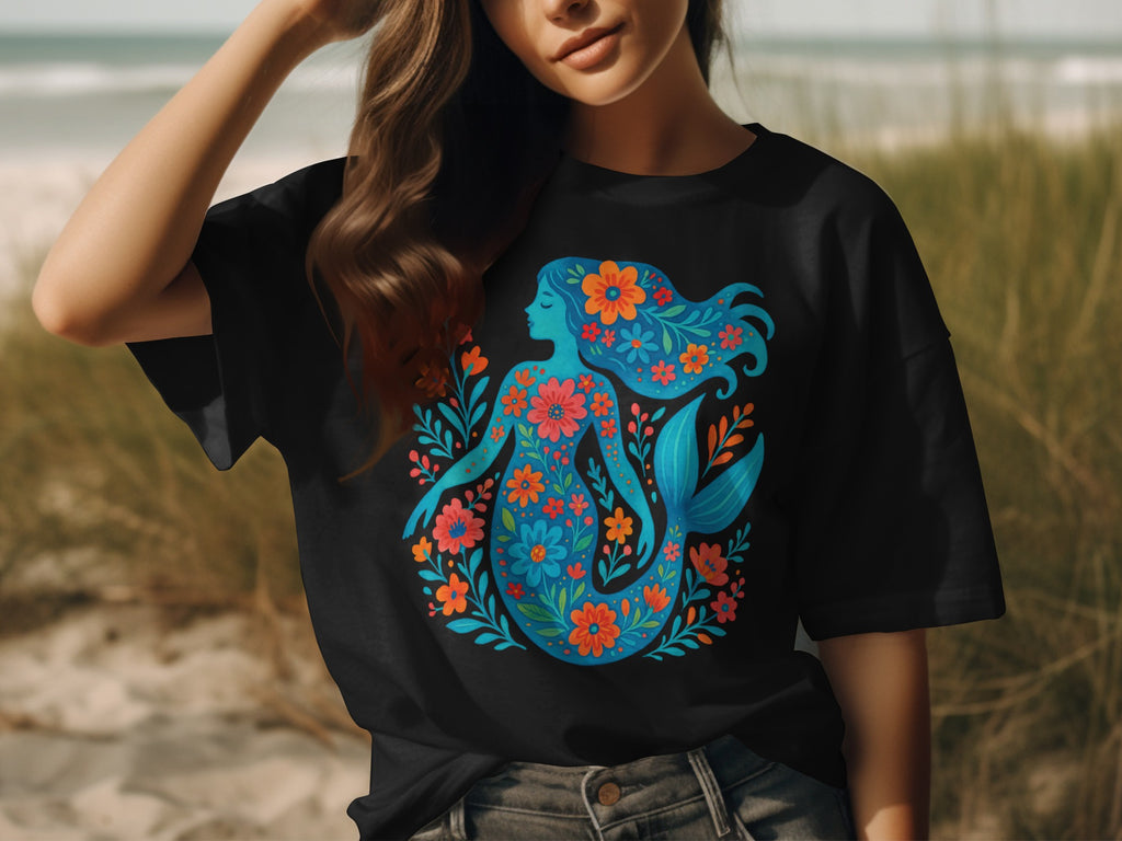 Black t-shirt with a blue mermaid design filled with colorful flowers.