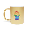 Gold mug with rainbow fist graphic and white interior.