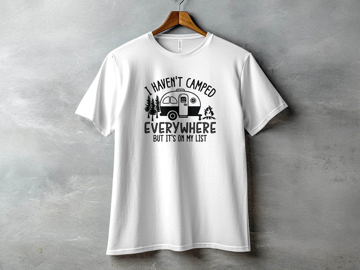 White t-shirt with black graphic reading "I HAVEN'T CAMPED EVERYWHERE BUT IT'S ON MY LIST".