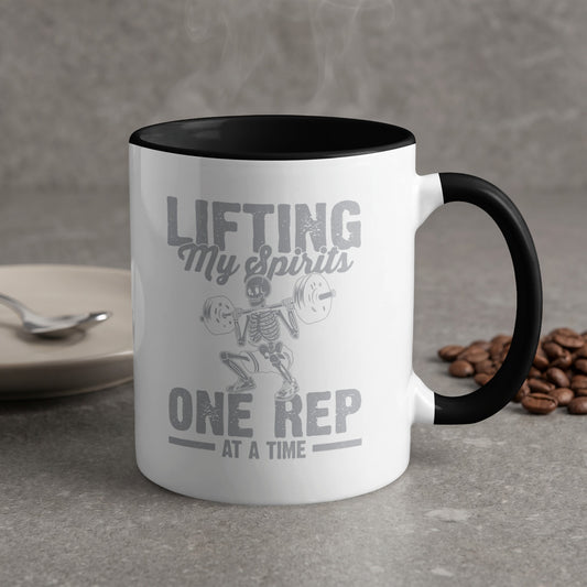 White mug with black rim, skeleton lifting weights, "Lifting My Spirits ONE REP AT A TIME".